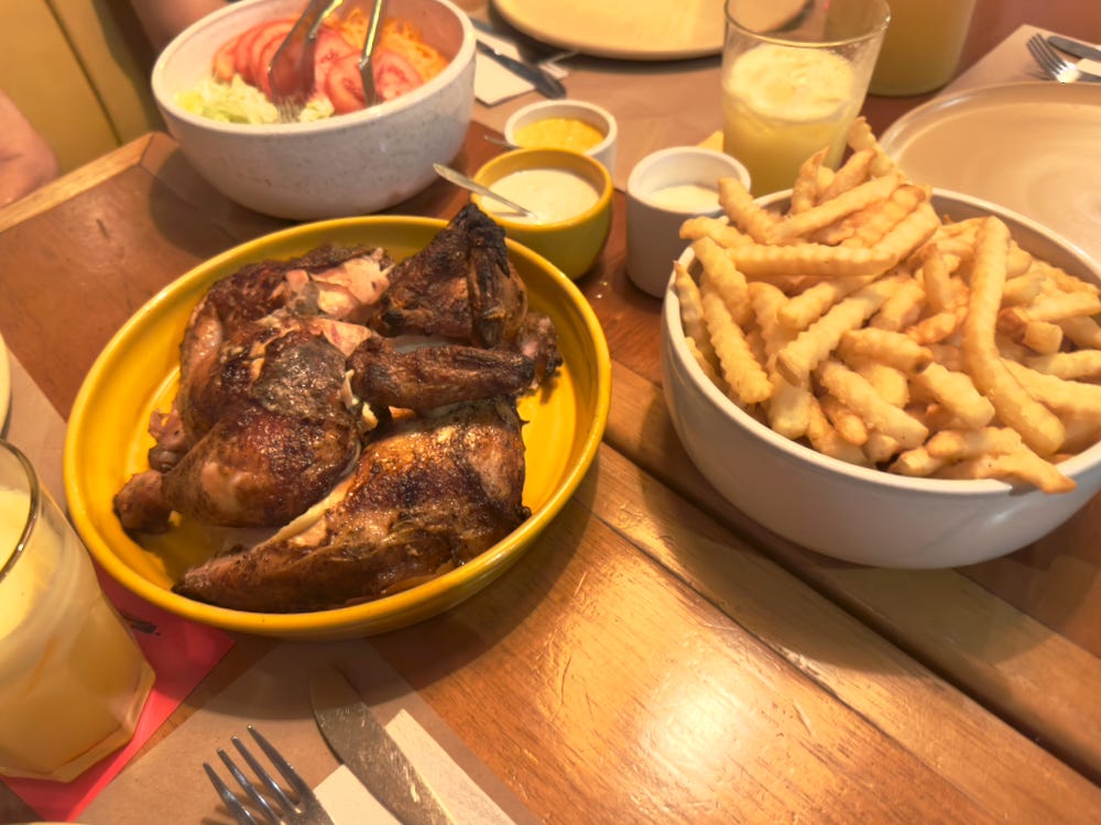 Whole Pollo a la Brasa, fries, salad, and trio of sauce at Primo's in San Isidro, Lima