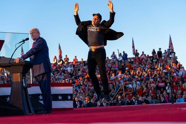 Elon Musk leaps into the air onstage, while former President Donald J. Trump speaks to the rally crowd in Butler, Pa.