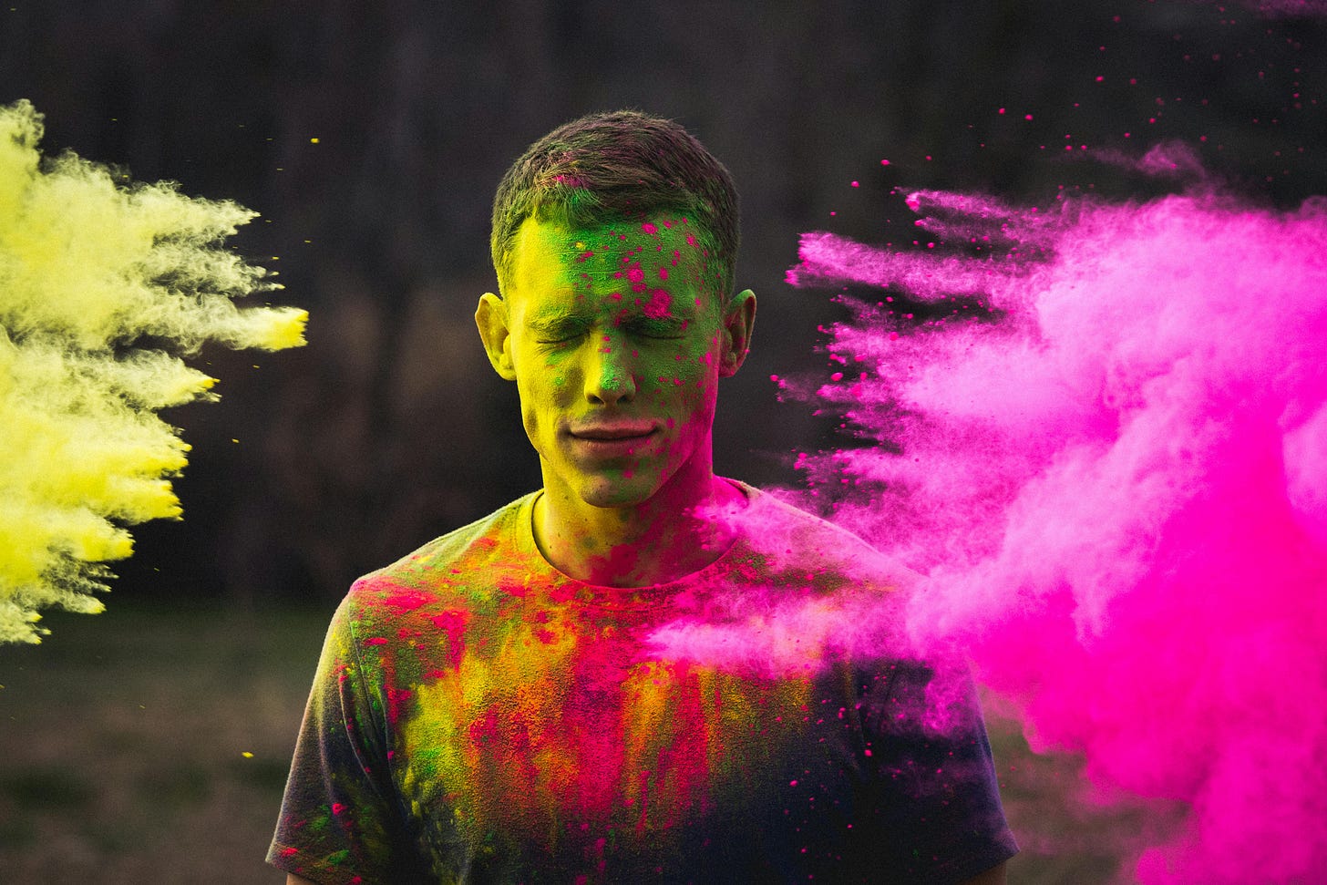 man getting coloured powder thrown on him from both sides man getting coloured powder thrown on him from both sides