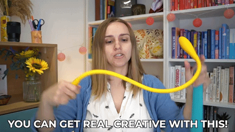 Hannah waving a bendy sex toy around. She's saying, "You can get real creative with this!"