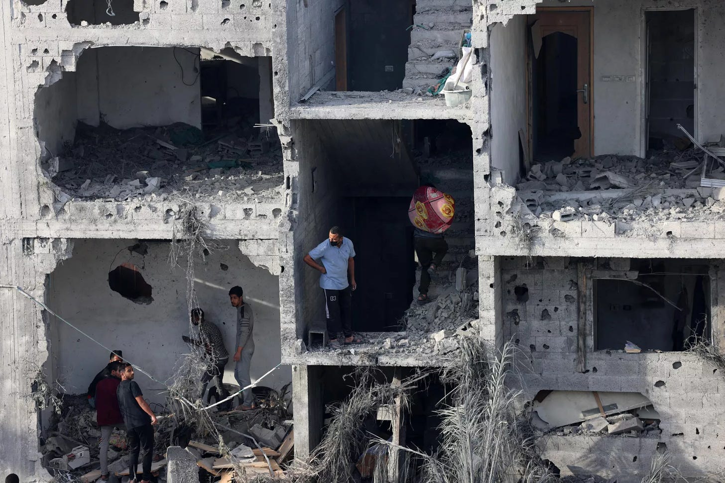 Οι άνθρωποι διασώζουν κάποια αντικείμενα από ένα κατεστραμμένο κτίριο μετά τον ισραηλινό βομβαρδισμό στη Ράφα στη νότια Λωρίδα της Γάζας, στις 11 Νοεμβρίου 2023. - Sputnik Ινδία, 1920, 16.11.2023