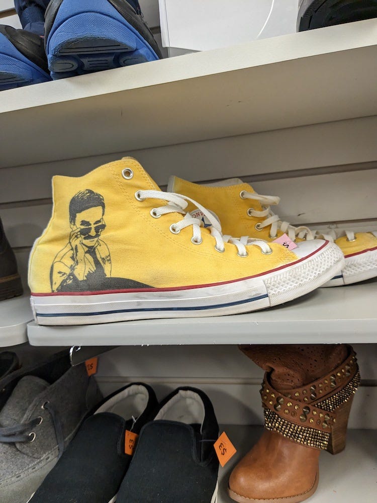 A pair of yellow Converse All-Stars shoes with the Liberty Mutual ad spokesman drawn on them