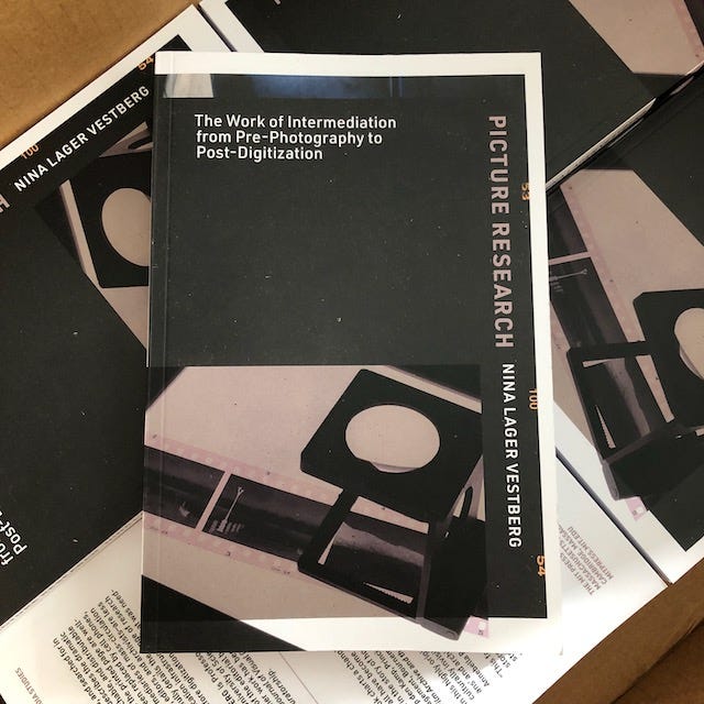 Cover of the book Picture Research: The Work of Intermediation from Pre-Photography to Post-Digitization by Nina Lager Vestberg. Mainly black cover with black and white picture of film negatives and loupe on a lightbox.