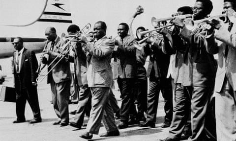 Louis Armstrong leads his bandsmen and local trumpeters on arrival at the airport in Accra, Ghana on 30 May, 1956.