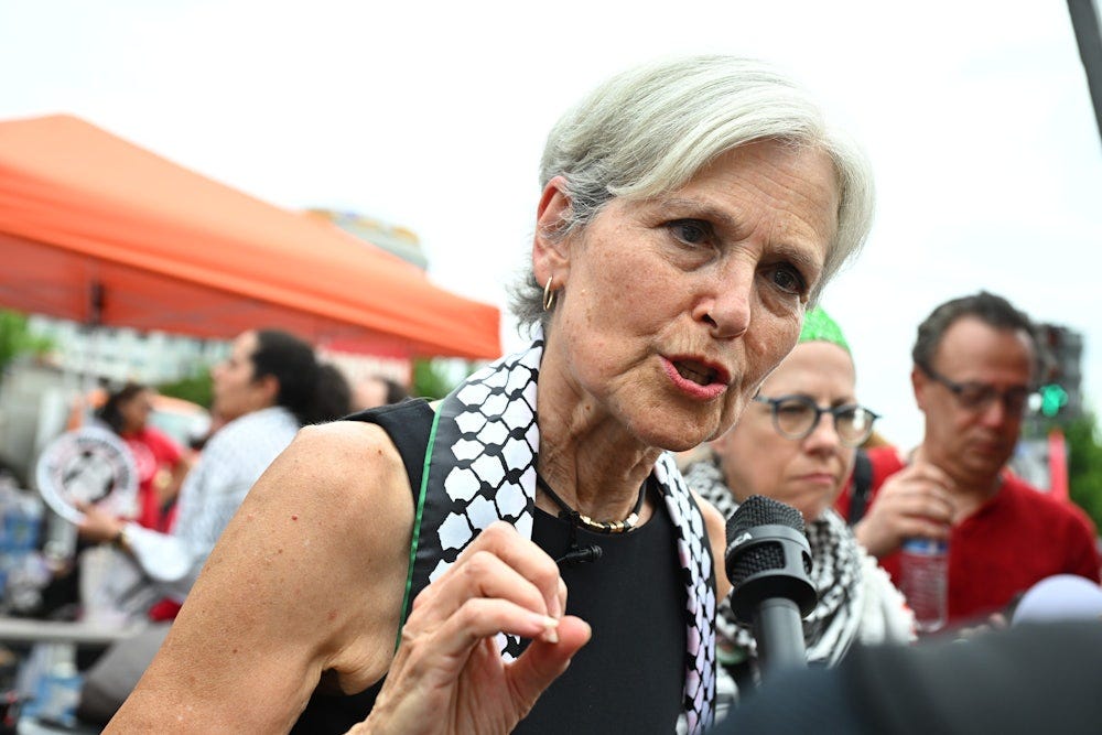 Jill Stein wears a keffiyeh and speaks into a reporter’s mic