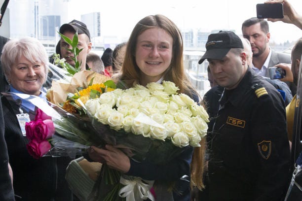 Russian agent Maria Butina, center, holds flowers upon her arrival from the United States at Moscow International Airport Sheremetyevo, Oct. 26, 2019.