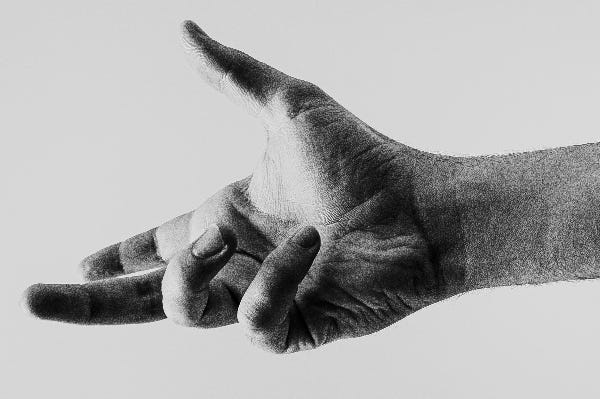 a black and white hand held out offering help a black and white hand held out offering help
