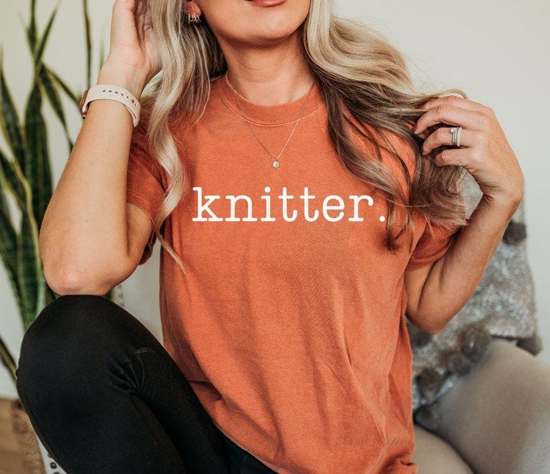 May include: A burnt orange t-shirt with the text 'knitter.' printed in white on the front.