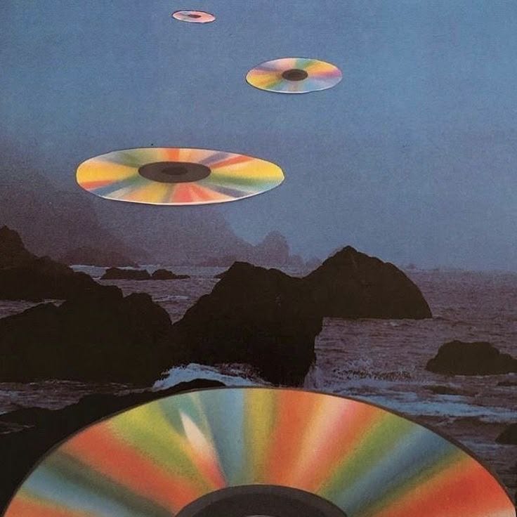 This may contain: an album cover with three discs flying in the air over water and rocks on the beach