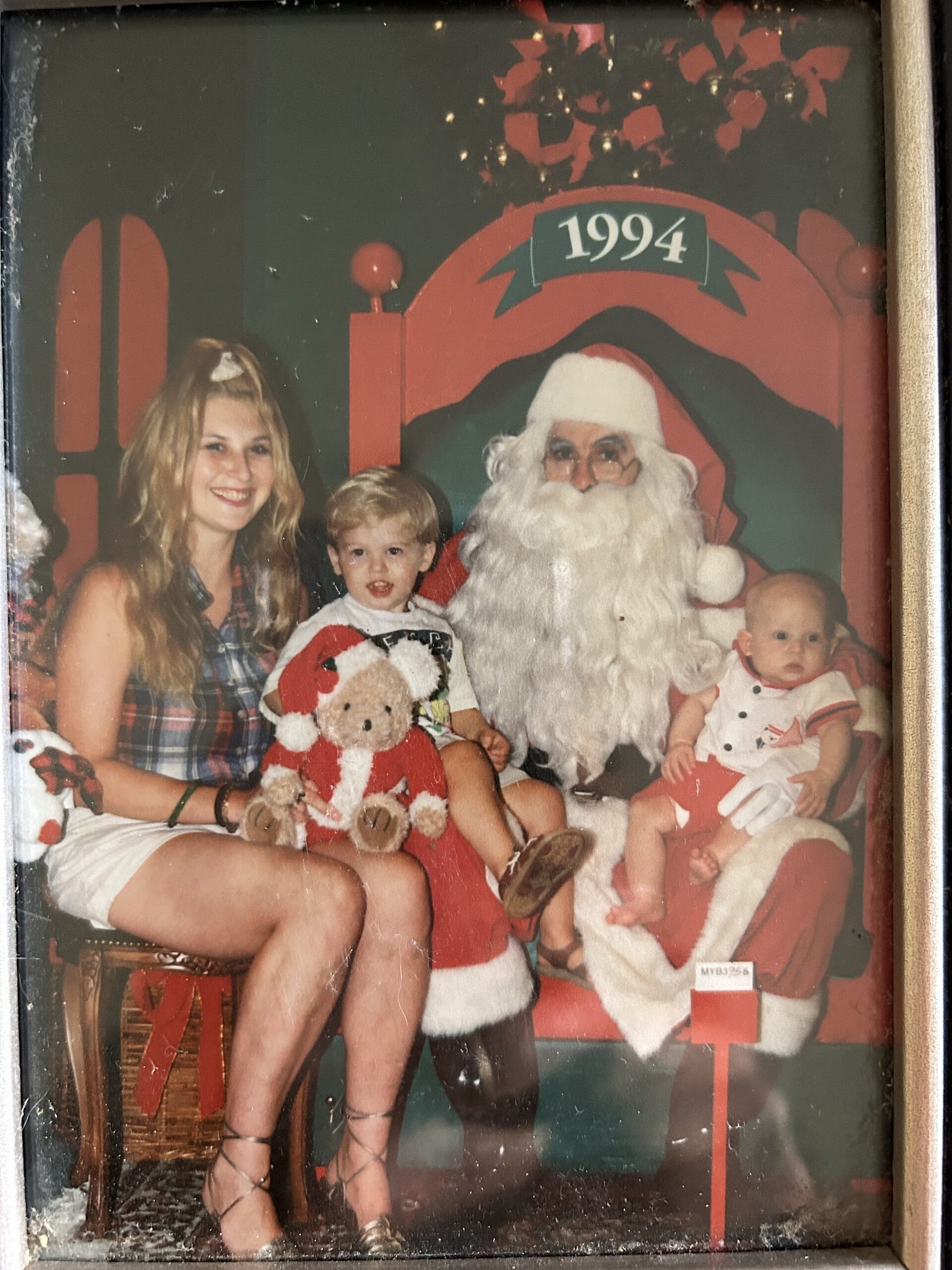 Family Christmas photo with Tammy and her two young boys sitting on Santa's lap