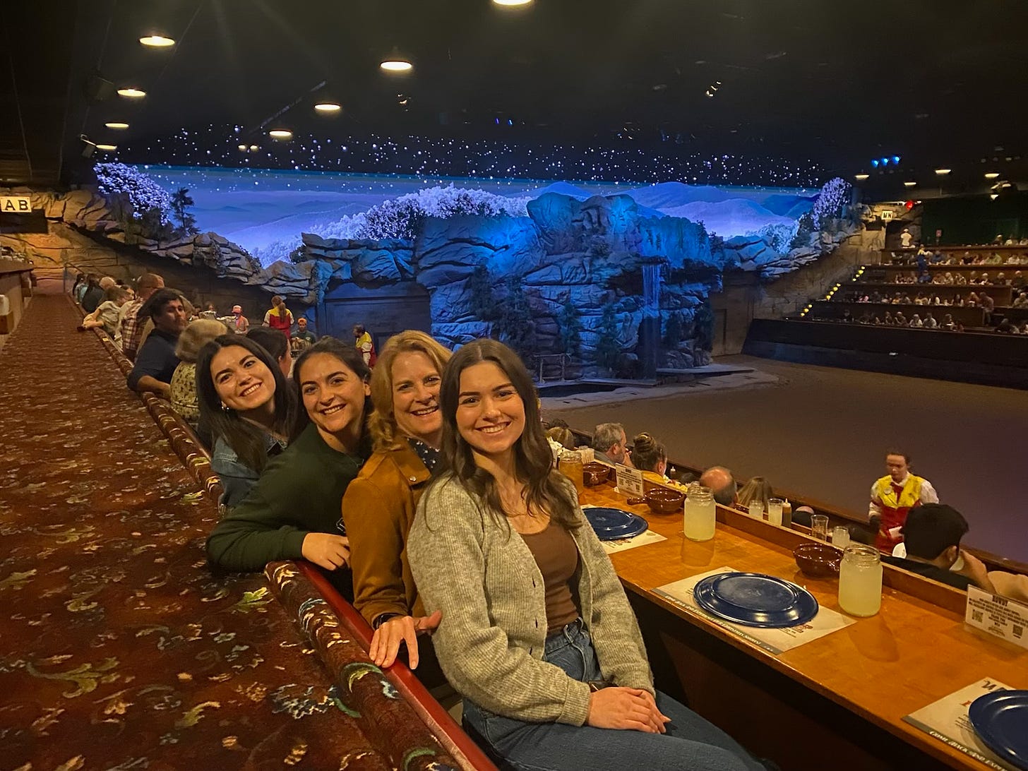 Mom sandwiched inbetween three 20-something daughters at the Dolly Parton Dinner Stampede Show