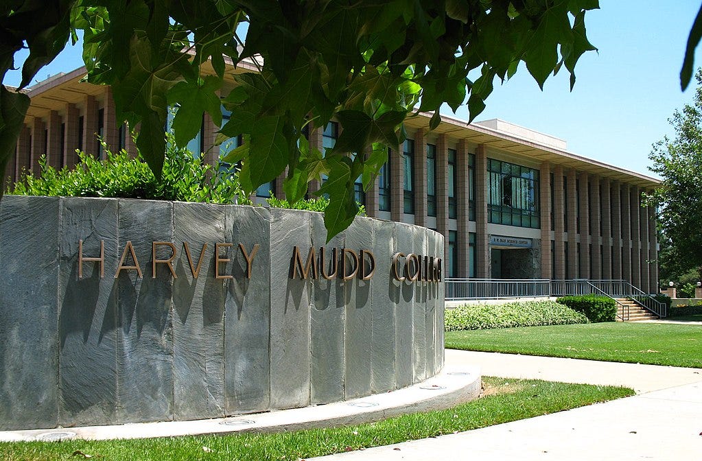 Entrance sign at Harvey Mudd College, with an academic building in the background.