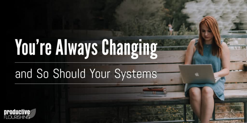 A woman with red hair sitting on a wooden bench, outside. Text Overlay: You're Always Changing and So Should Your Systems