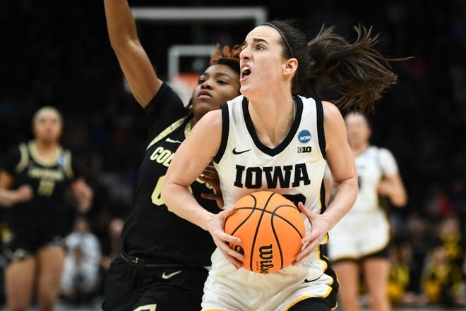 Iowa's Caitlin Clark (22) looks for an open shot while guarded by Colorado's Jaylyn Sherrod.