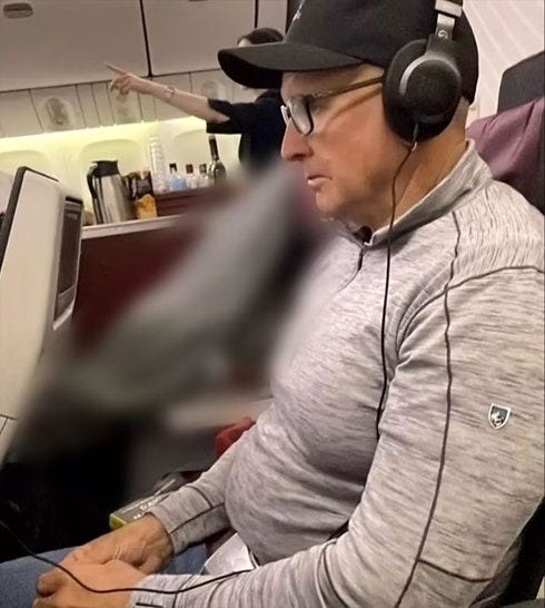 man sits by dead body on plane 1