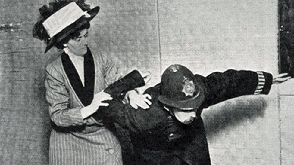 Photograph of Mrs Edith Garrud demonstrating how to incapacitate a policeman by twisting his arm up his back.