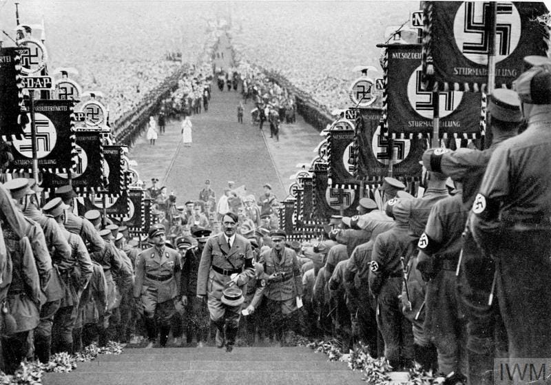 Hitler, flanked by the massed ranks of the Sturm Abteilung (SA), ascends the steps to the speaker's podium during the 1934 harvest festival celebration at Bückeburg.