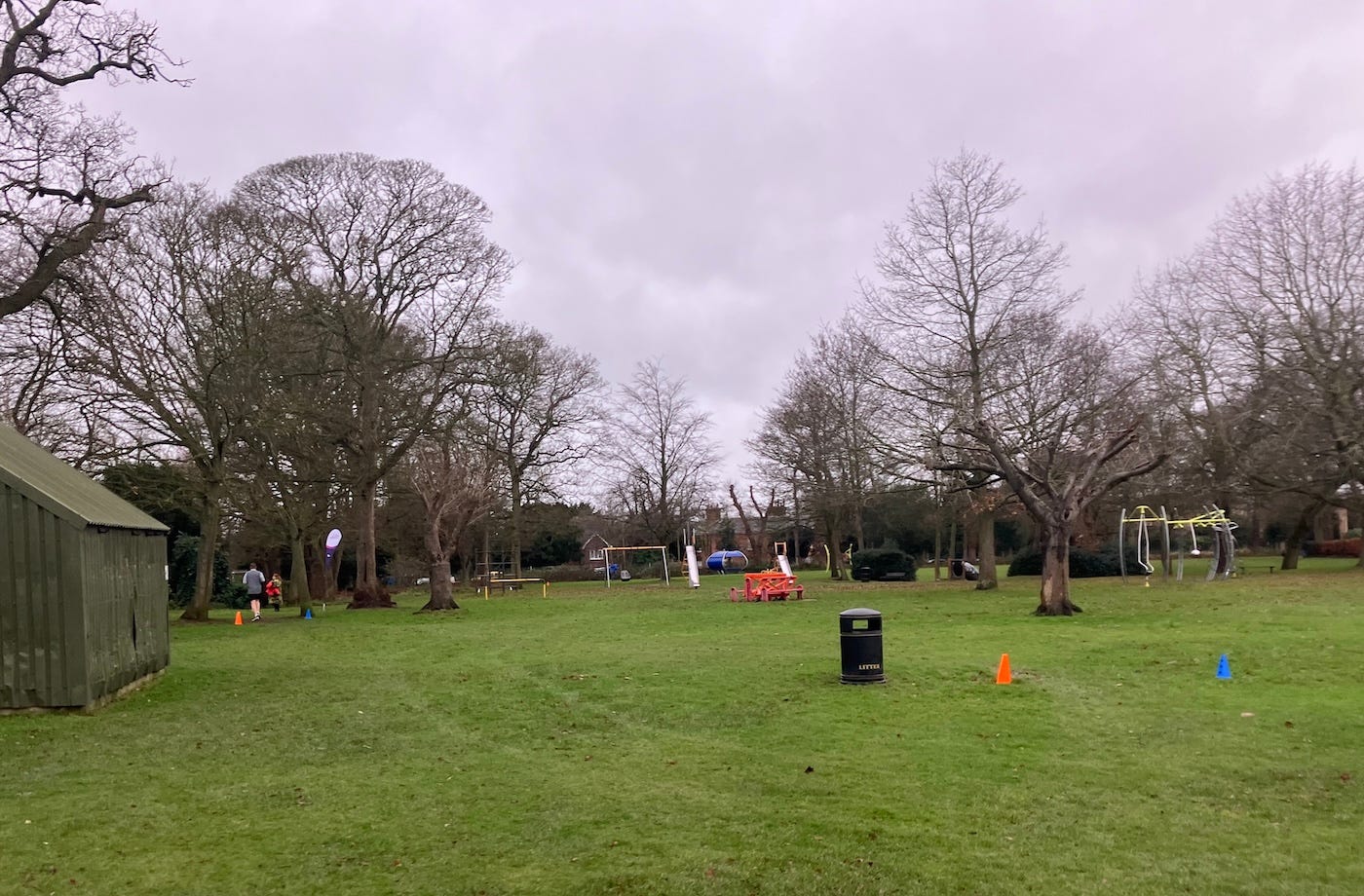 A field with trees, cones mark the route through the middle