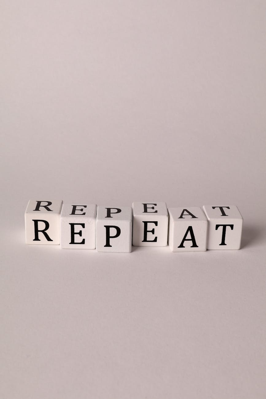 photo of cubes with letters forming the word repeat