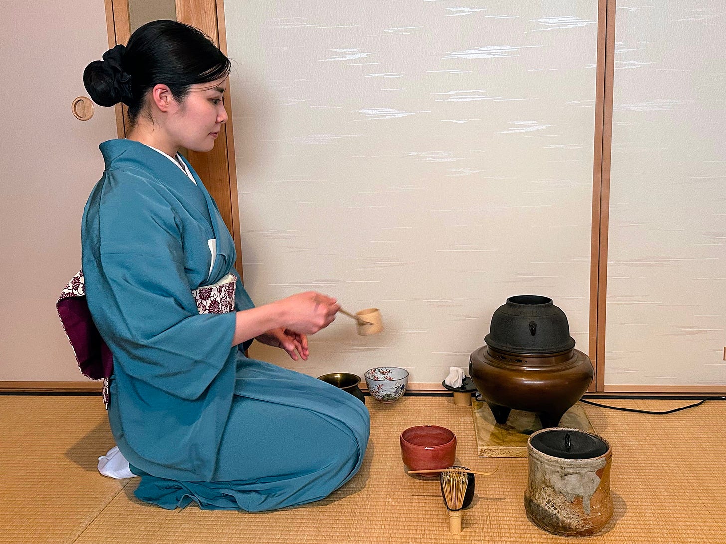 a picture of a woman carrying out tea ceremony in Japan