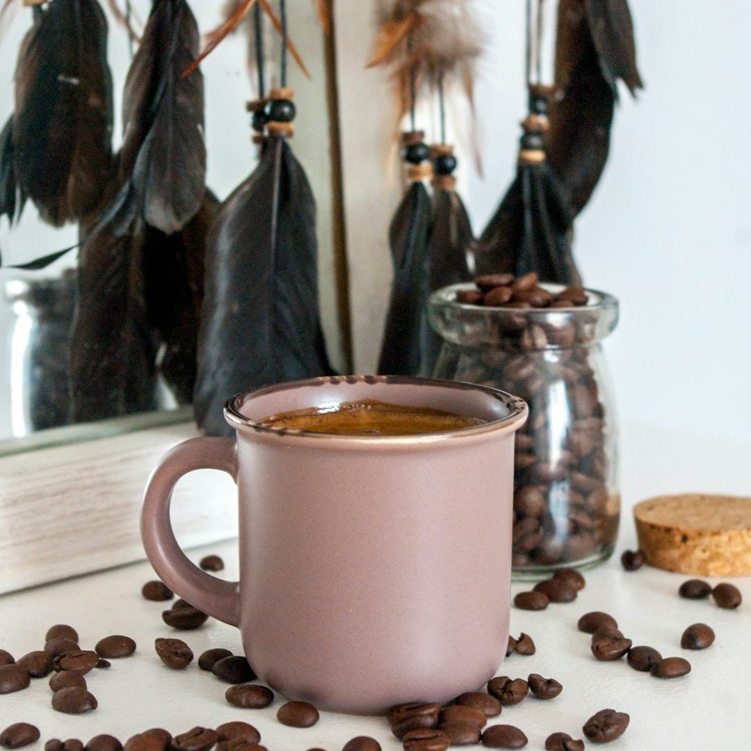 white ceramic mug with coffee beans on brown wooden table white ceramic mug with coffee beans on brown wooden table