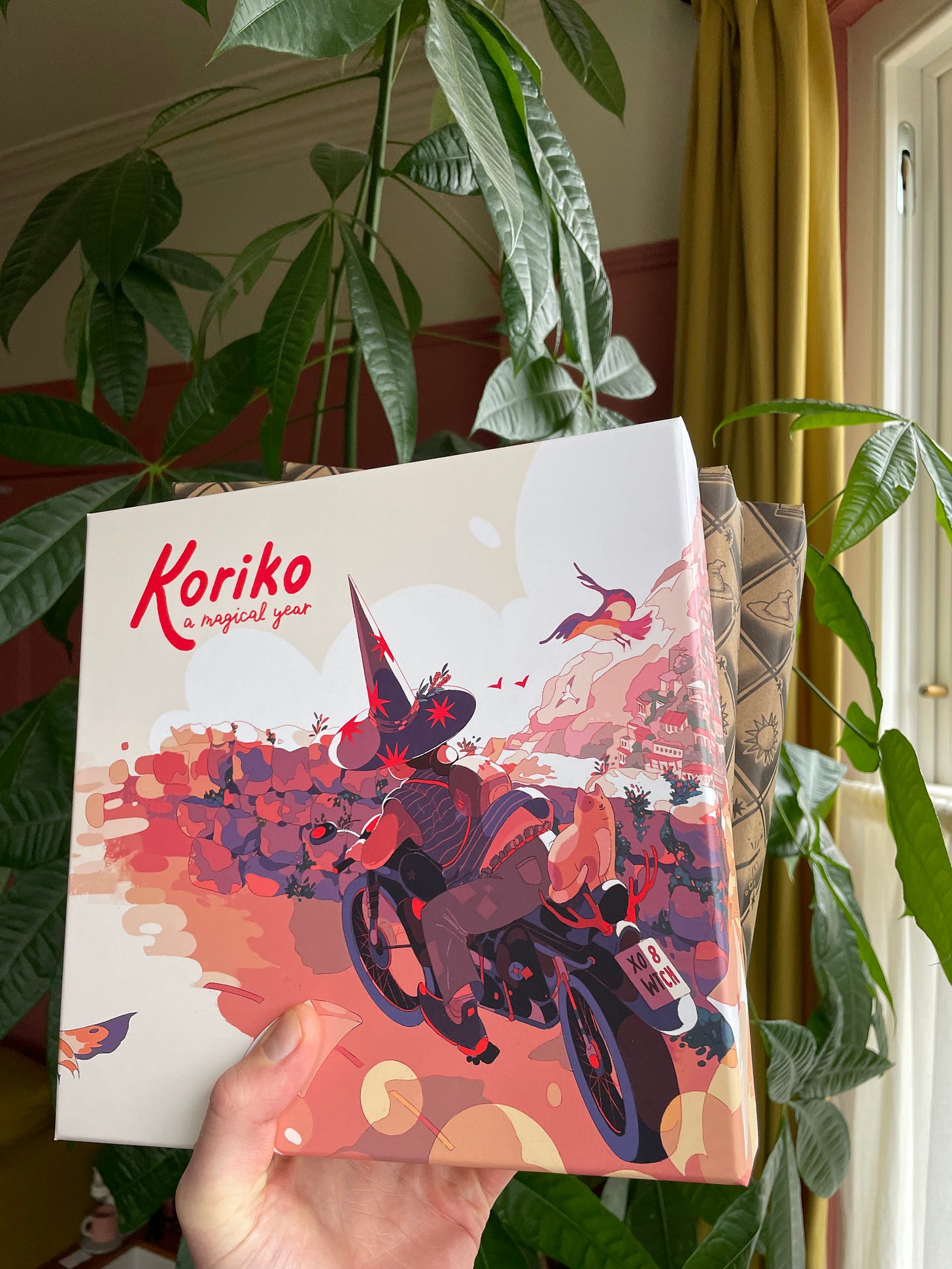 A photo of the Koriko boxed edition, unwrapped, with two copies wrapped in brown paper behind it.