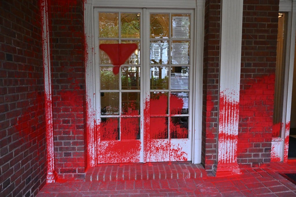 Piros festék fröccsent egy bérházra.