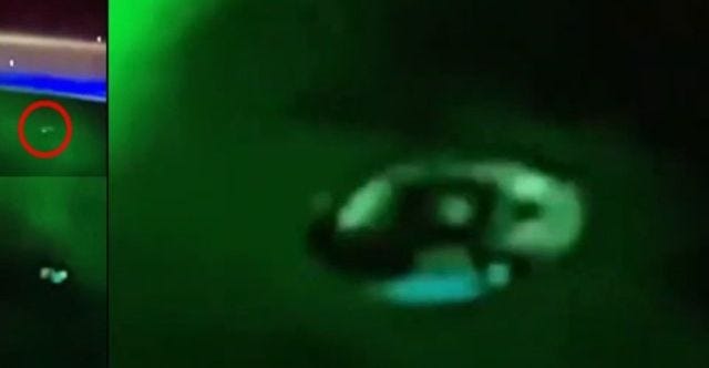 Disc shaped alien spacecraft flying through the northern aurora