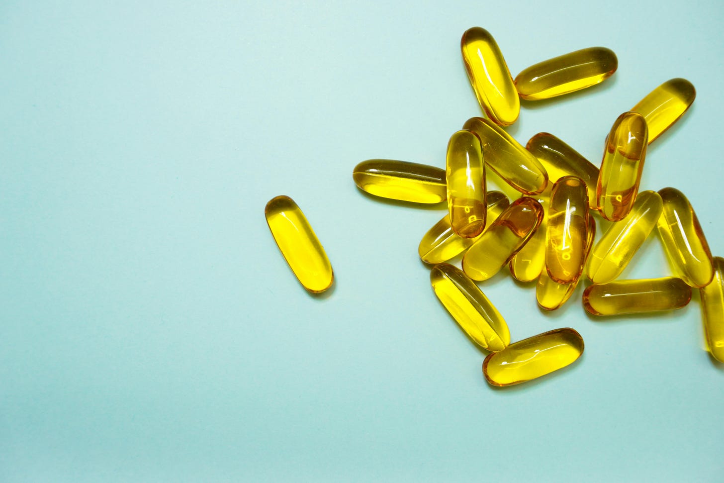 Yellow coloured supplements pills on blue background