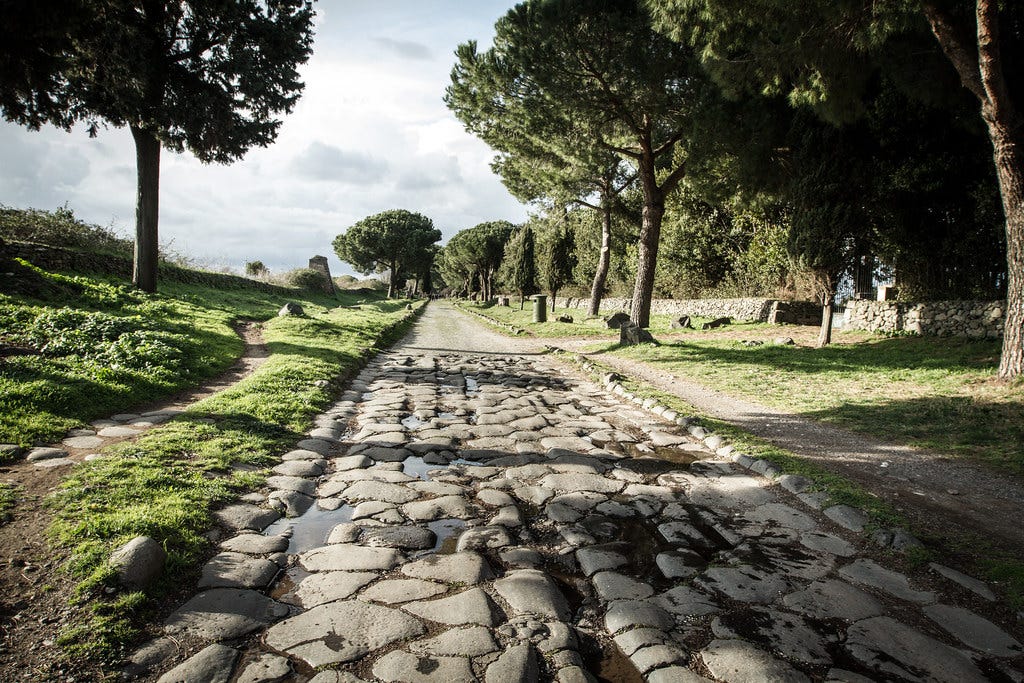 photo of the appian way outside of rome with ancient roman road