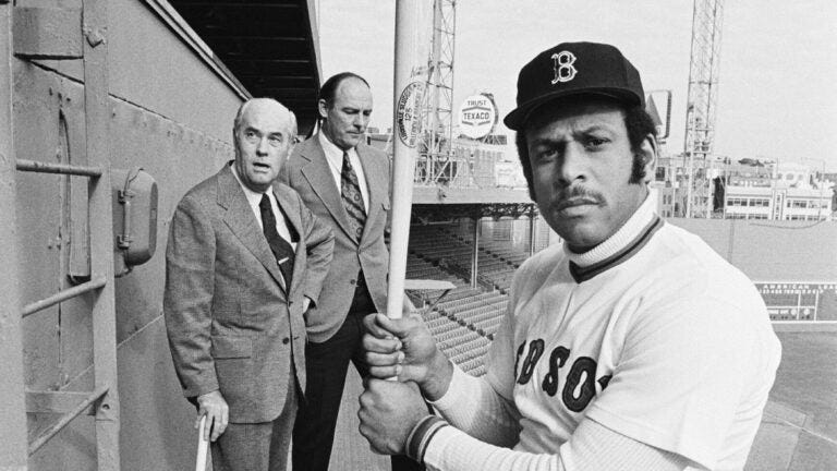 FILE- Orlando Cepeda, right, swings a bat for photographers after the Boston Red Sox announced they had signed Cepeda as their first designated hitter, at Fenway Park in Boston.