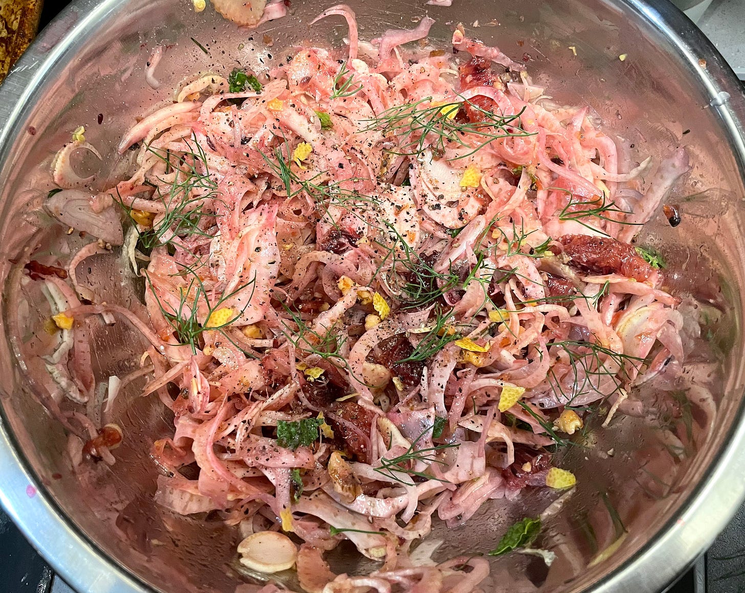 raw fennel and blood orange salad with walnuts and shallots in silver bowl
