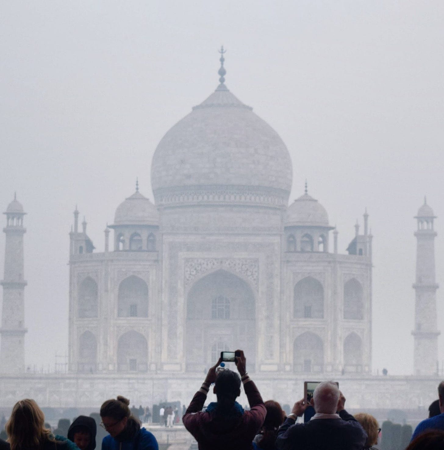 Visitors photograph the Taj Mahal in early morning fog