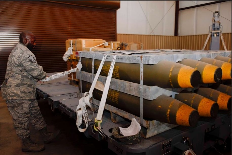 U.S. service member moving large munitions, representing logistical strains on the military.