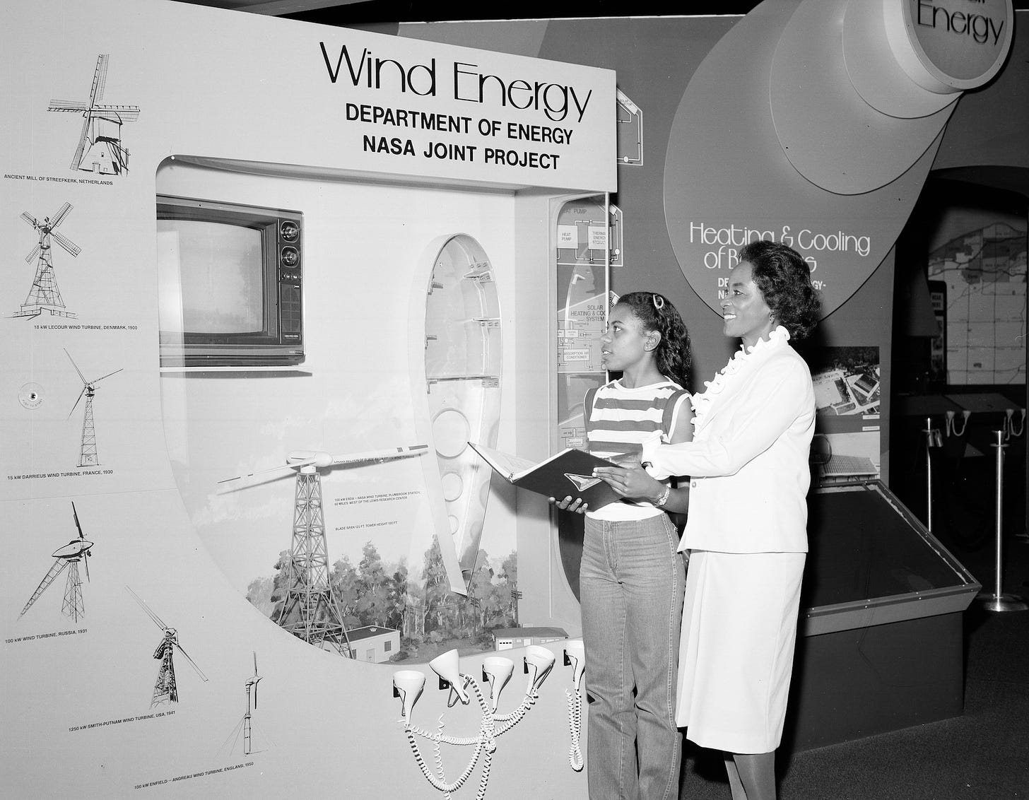 Annie Easley with young black girl in front of a Wind Energy project installation. Photo is black and white.