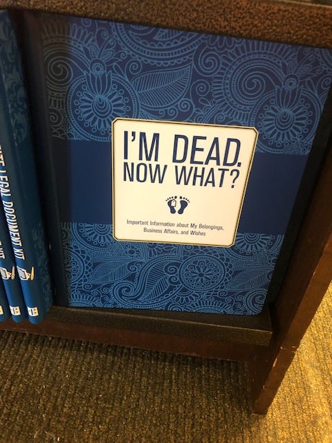 A book on a shelf titled "I'm Dead. Now What?"