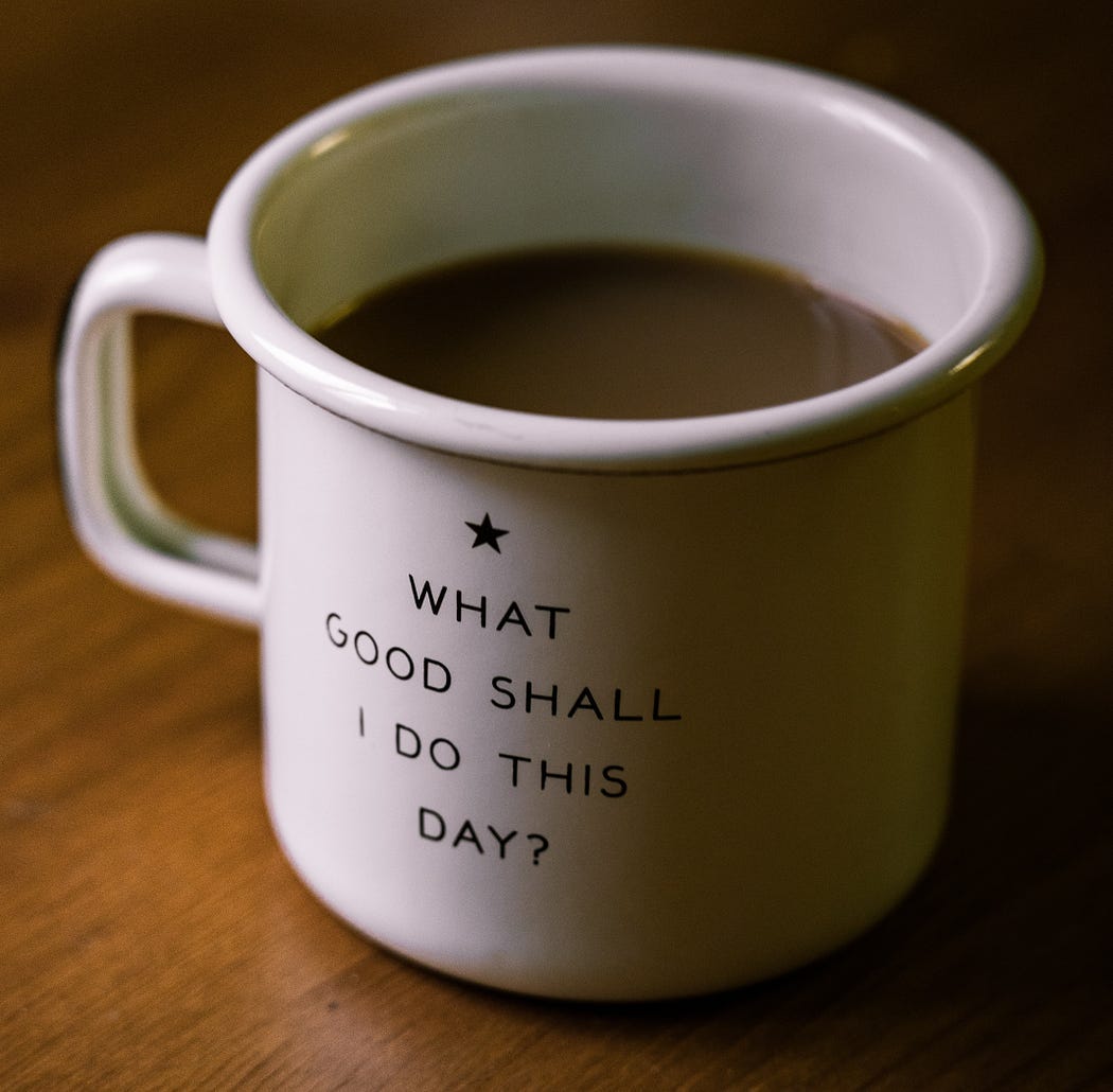 Full white ceramic coffee cup that say “What good shall I do this day?”