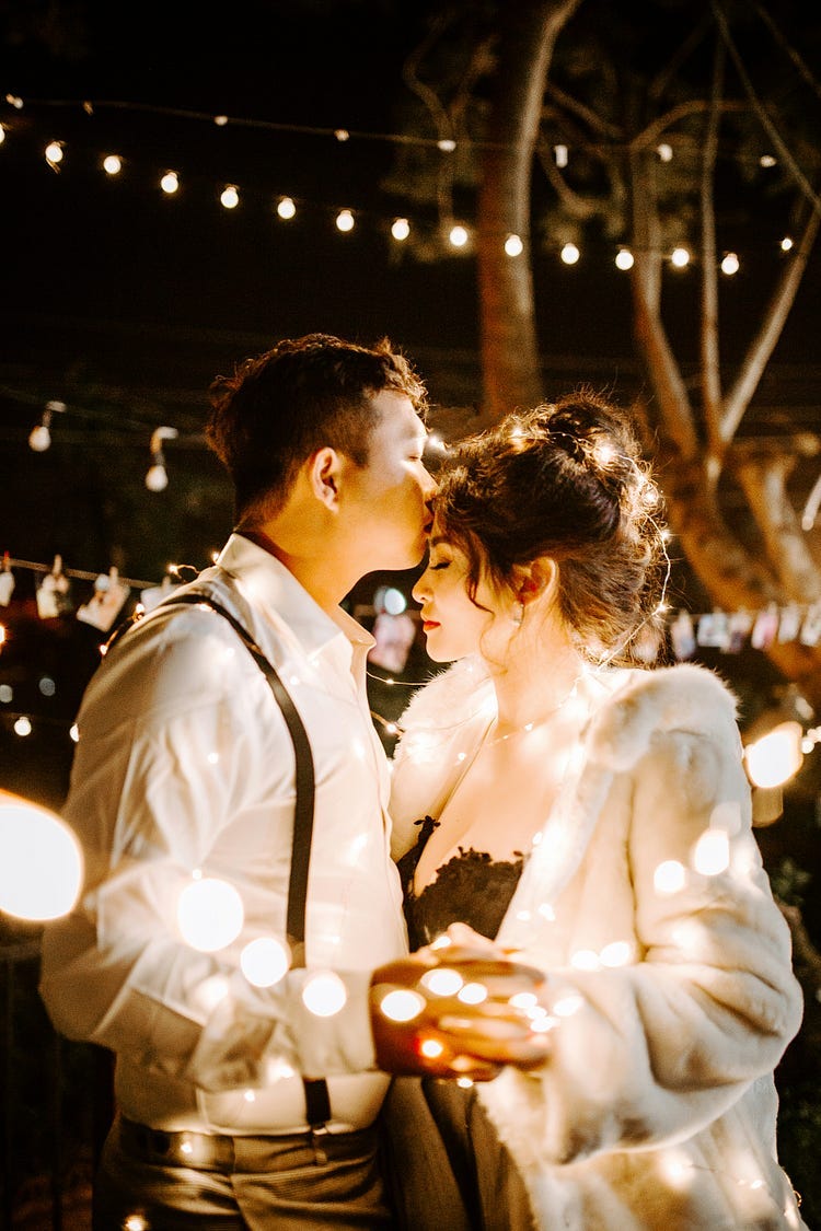 Couple at a Fair with lights.