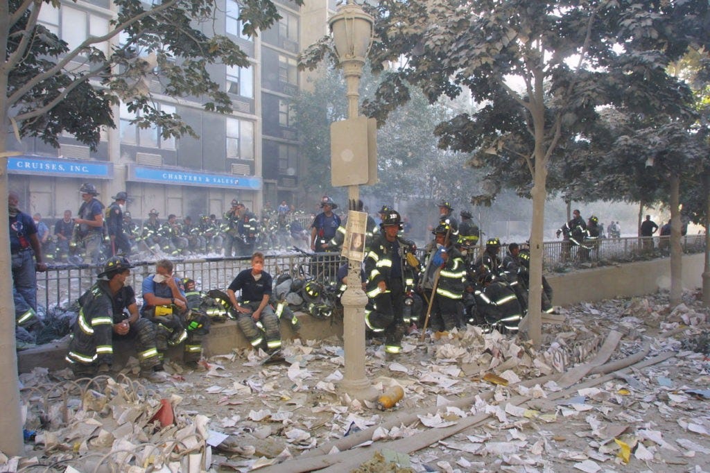 394277 10: New York City firefighters take a rest frm rescue operations at the World Trade Center after two hijacked planes crashed into the Twin Towers September 11, 2001 in New York. (Photo by Ron Agam/Getty Images)