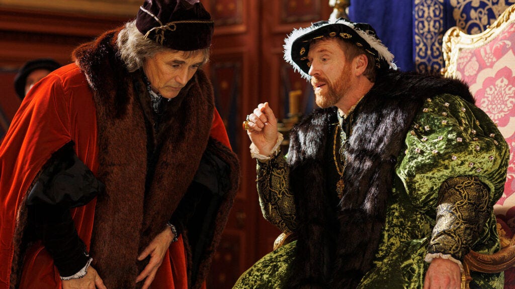 A scene from the MASTERPIECE on PBS historical drama Wolf Hall: The Mirror and the Light with Mark Rylance as Thomas Cromwell, leaning in to hear Damian Lewis as Henry VIII speak.