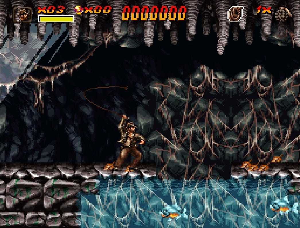 A screenshot of Indiana Jones in the first level of Greatest Adventures, using his whip. The whip is mostly overhead, right after the motion of using it, as it launches itself forward and in front of Jones.