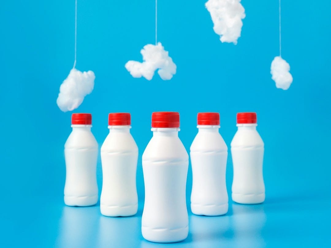 five white plastic bottles on blue surface