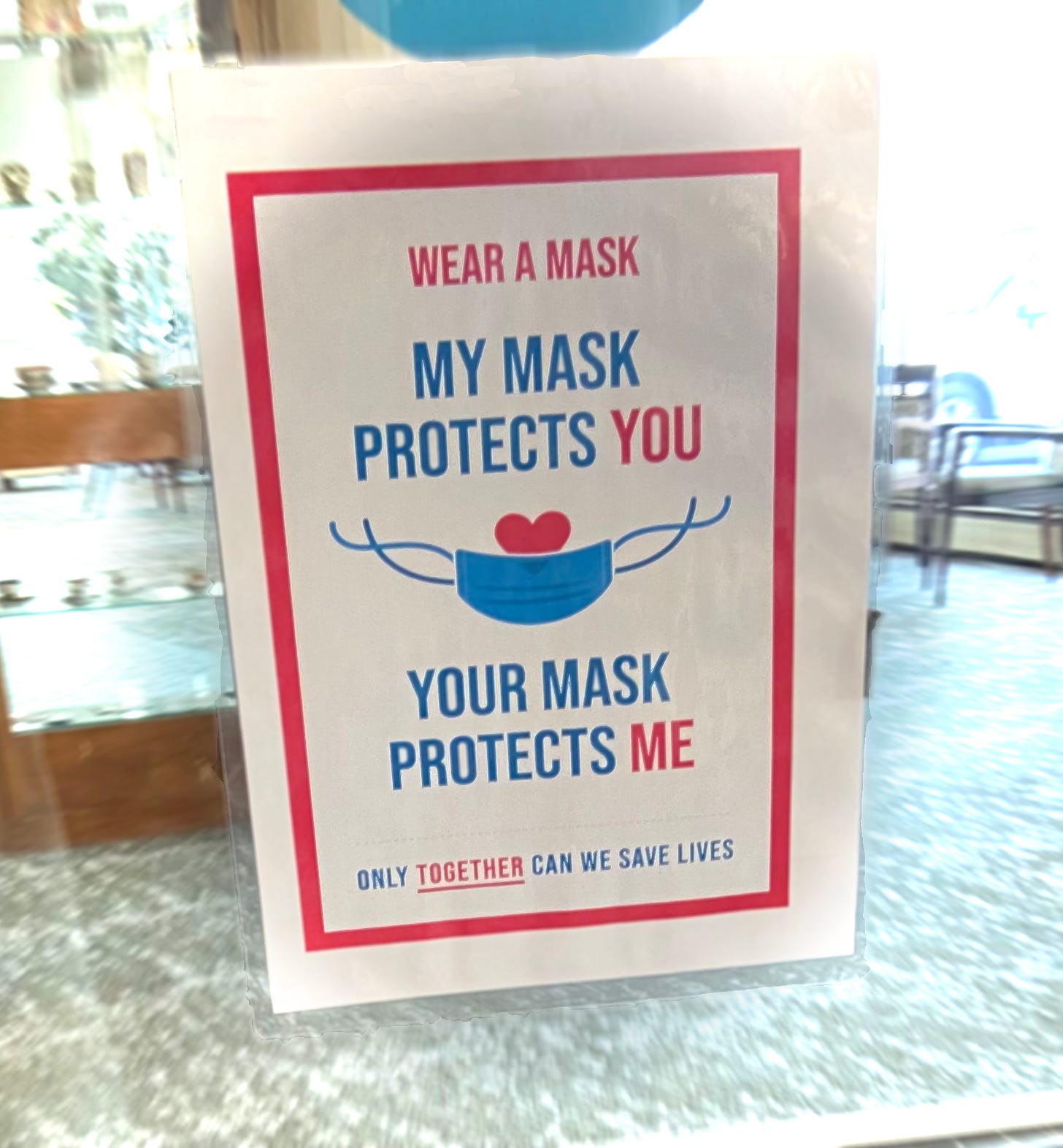 Spotted at senior housing in Palo Alto California. (The photo is of a sign posted on a glass door window, the sign shows the image of a mask with a heart peeking out from behind it, and the sign states Wear a mask. My mask protects you. Your mask protects me. Only together can we save lives.)