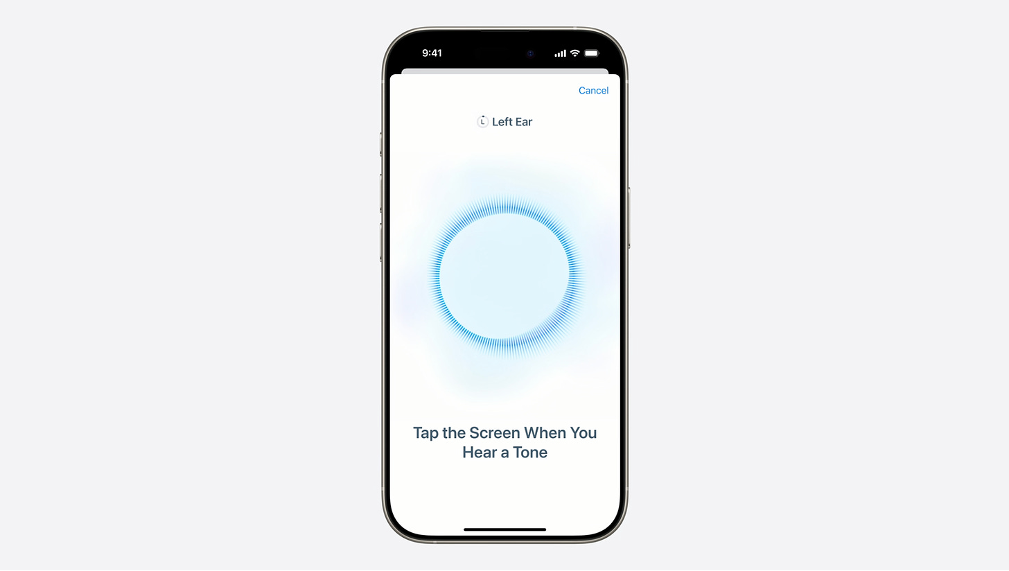 A still from an Apple video. It shows an iPhone with a white screen up. On the screen is a blue circle with spikes implying sound. It says "Left Ear. Tap the screen when you hear a tone."