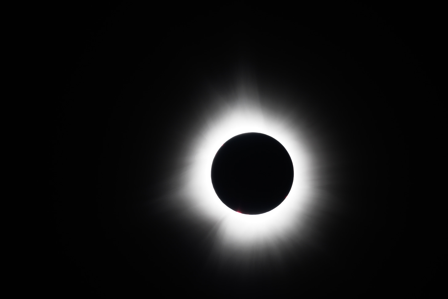 Totality: the moon is completely covering the sun; it’s a dark circle surrounded by the white glow of the corona.