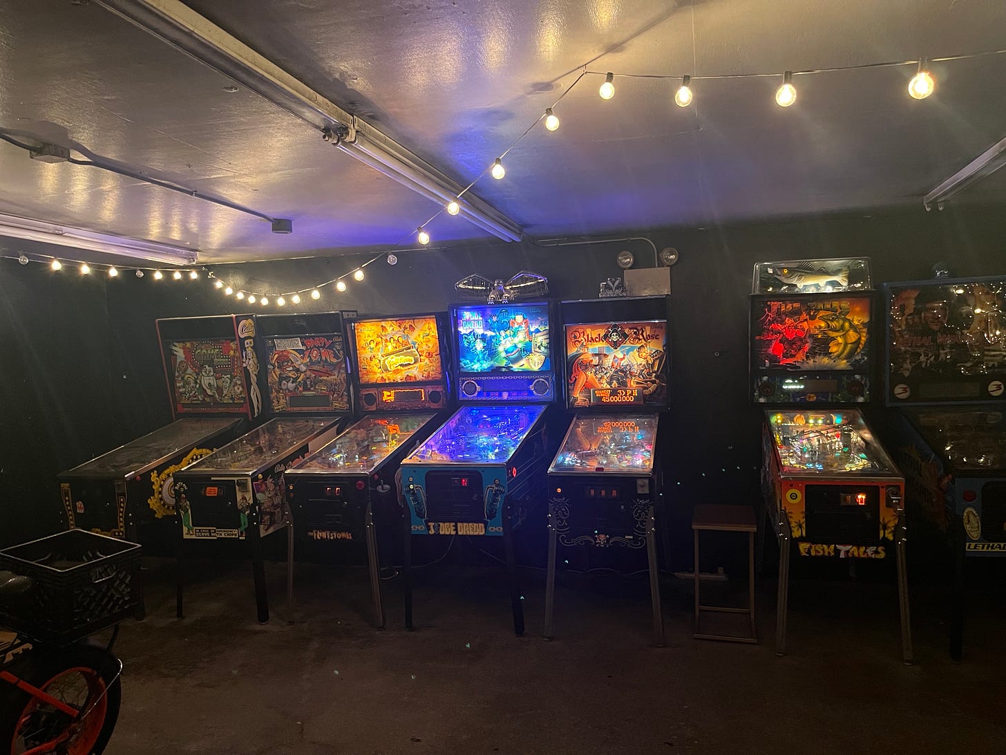 A row of seven different pinball machines.
