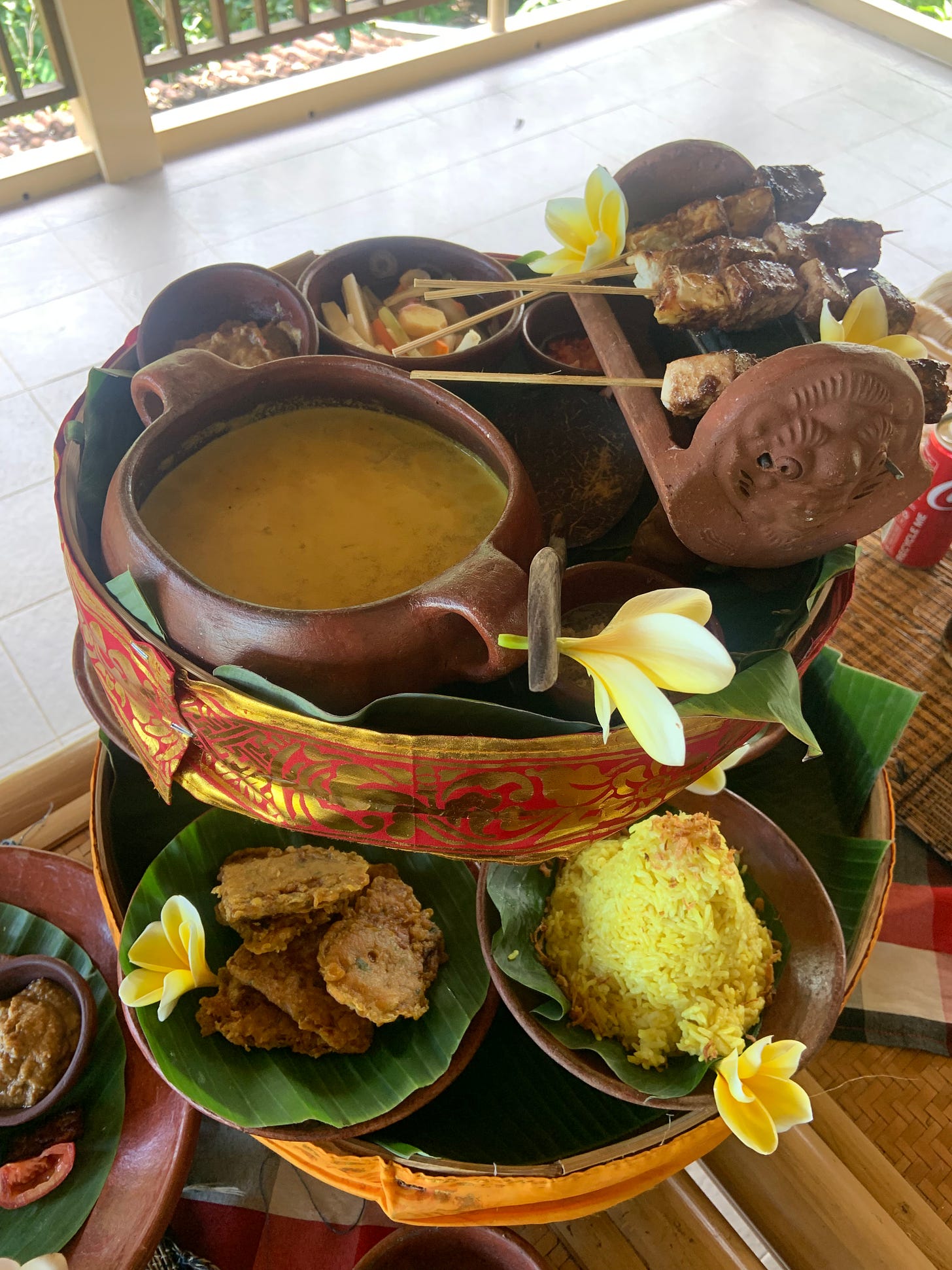 Coconut curry, satay tofu/tempe, yellow rice served in brown ceramic bowls