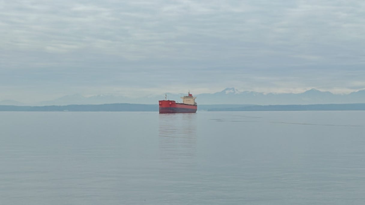 An orange ship with snowy mountains in the background