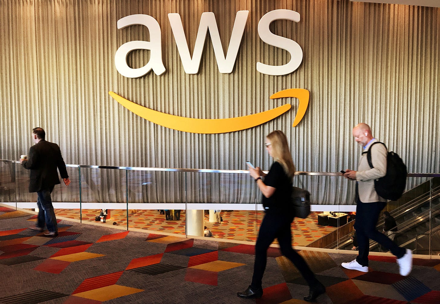 Attendees at Amazon.com Inc annual cloud computing conference walk past the Amazon Web Services logo in Las Vegas Attendees at Amazon.com Inc annual cloud computing conference walk past the Amazon Web Services logo in Las Vegas