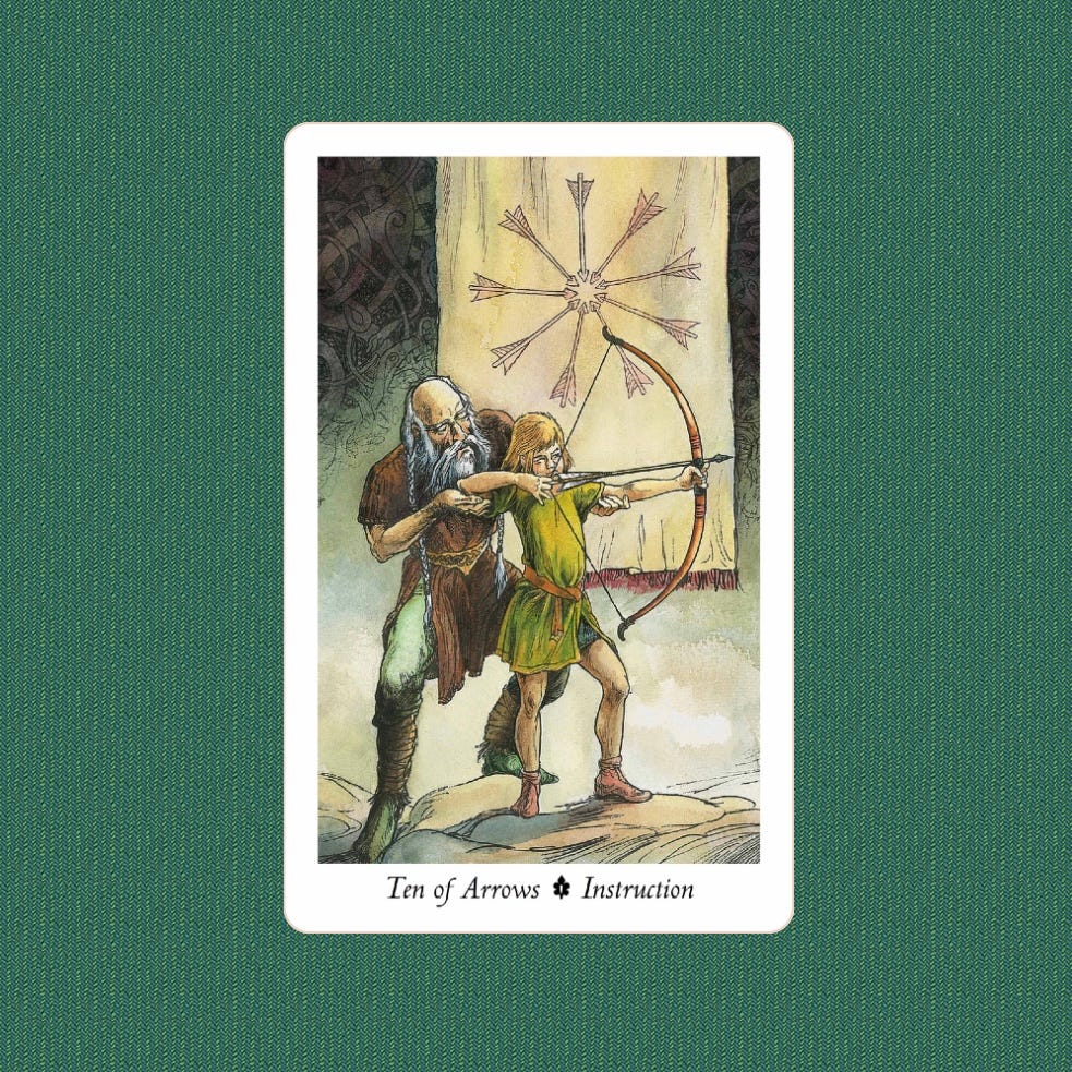 Tarot card depicting an old man teaching a young child to draw a bow. In the background is a wall hanging with nine arrows making a spoked wheel.